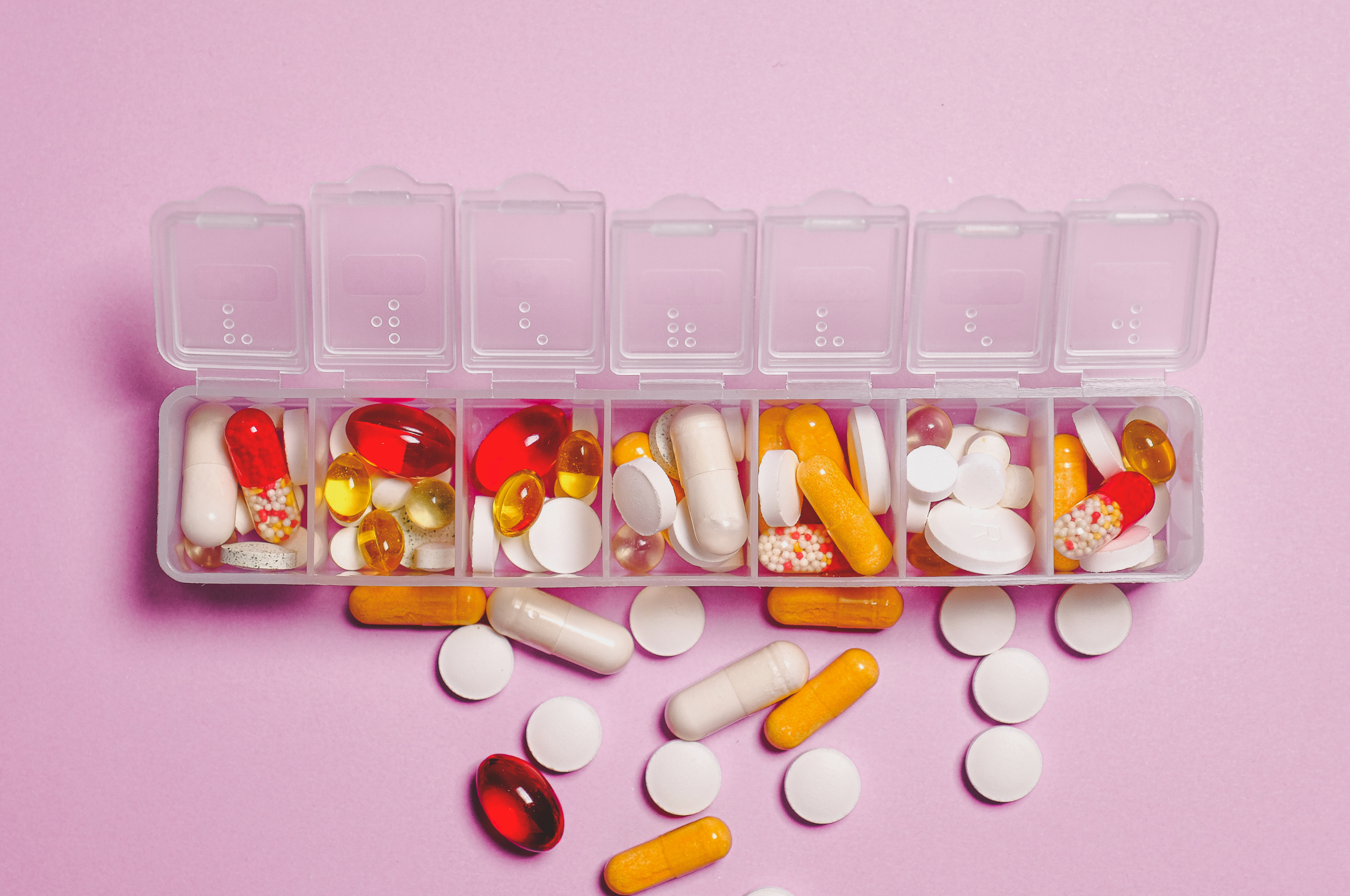 Pill organizer sitting on a pink background