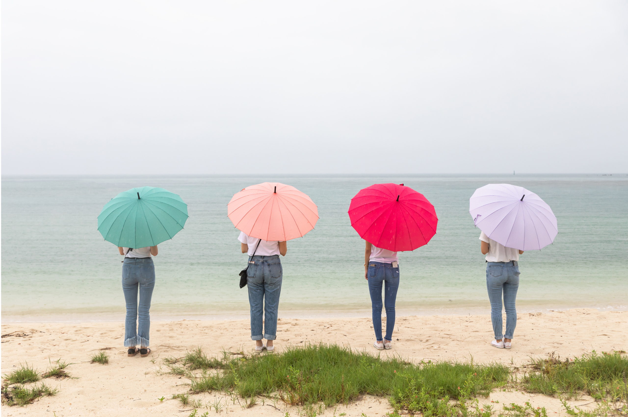 4 women standing on a beach with different colored umbrellas symbolizing the different types of PCOS